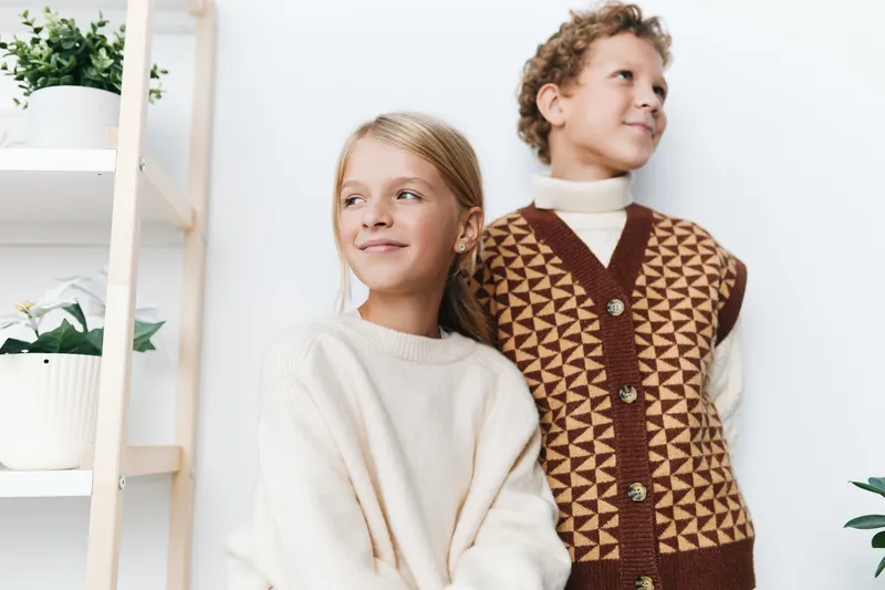 Authentic lifestyle image of two children in a cozy home setting, capturing a playful moment that hints at school readiness, imagination, and everyday joy.