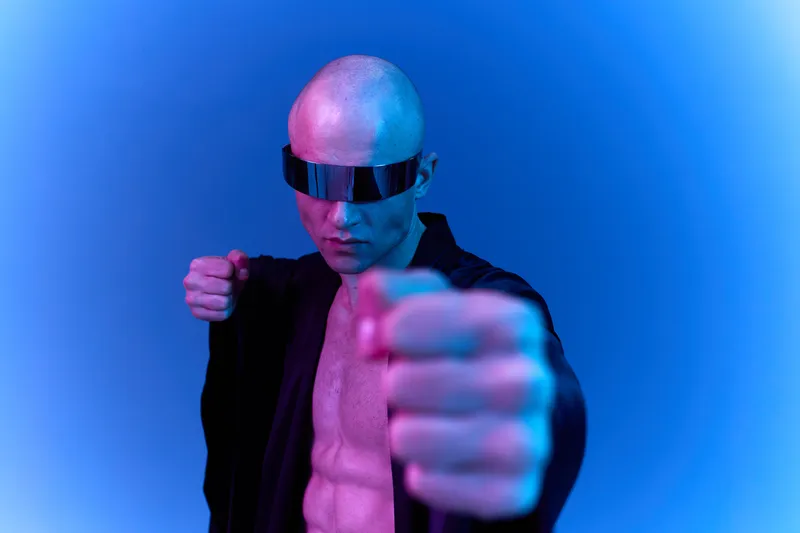 Dynamic man in futuristic attire with sunglasses, striking a powerful pose against a gradient background. This image embodies strength and modernity in vibrant colors.