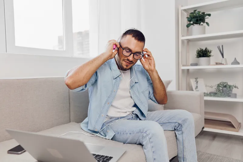 A focused man enjoying a digital detox while listening to music, creating a peaceful work-life balance in a cozy home environment, inspiring serenity and mindfulness.