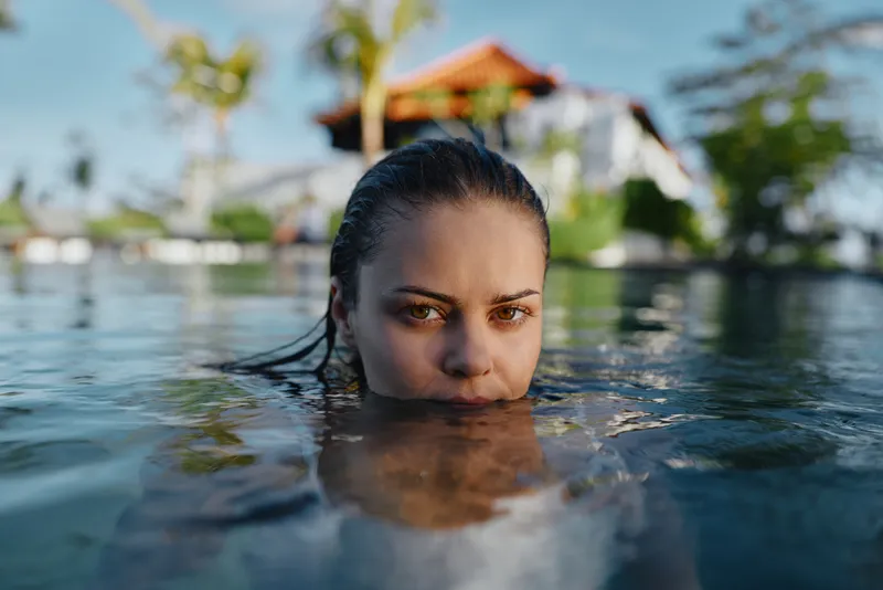 Water pool swimming person woman face shallow aquatic leisure outdoor, closeup of a woman in a pool with serene expression under bright daylight, capturing calm summer recreation and reflective mood