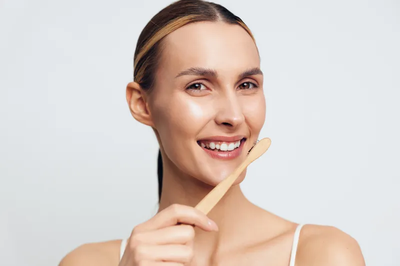 Smiling woman with headband, isolated portrait, skincare and beauty treatment, spa healthy skin glow, holding fingers near cheek, facial care for calm relaxation, on clean white background
