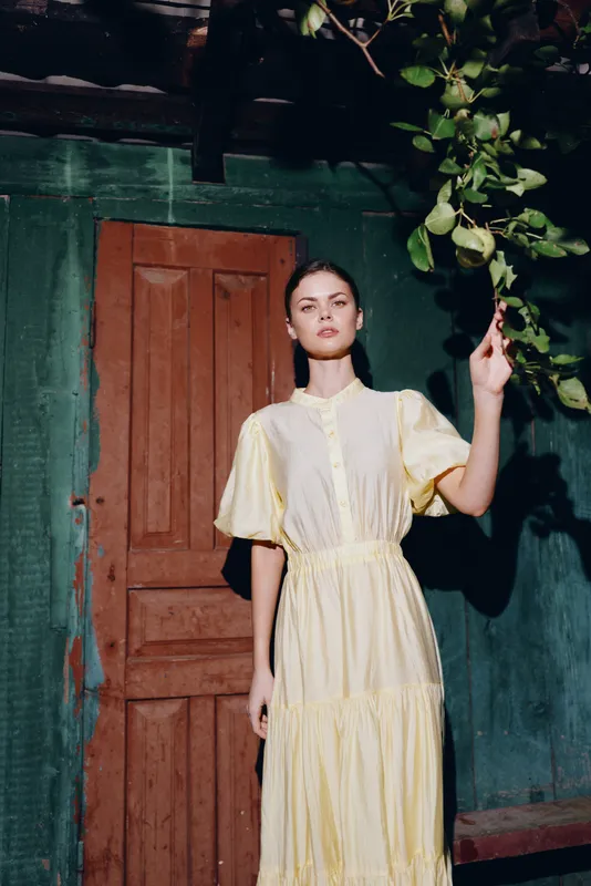 woman dress portrait doorway leaves sunlight standing elegant vintage fashion portraiture with serene expression and authenticity inclusivity in outdoor warm light