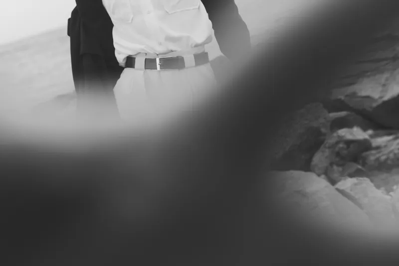 Business professional on a rugged outdoor path in grayscale, showcasing attire and journey, symbolizing perseverance, ambition and leadership under challenging terrain