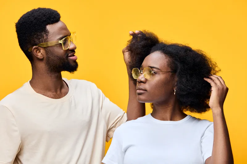 A stylish couple posing against a vibrant yellow background, showcasing confidence and playfulness Their unique outfits reflect personality and modern trends, perfect for fashion related themes