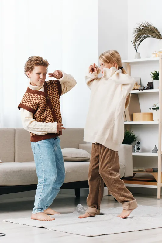 Authentic depiction of children in a playful moment at home, capturing school life spirit and everyday lifestyle with laughter, movement, creativity, and genuine energy.