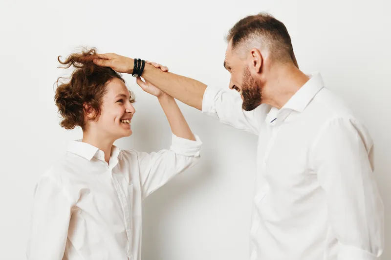 A professional man enthusiastically celebrates a milestone with a colleague against an isolated colored background, conveying confidence, teamwork, and upbeat business energy.