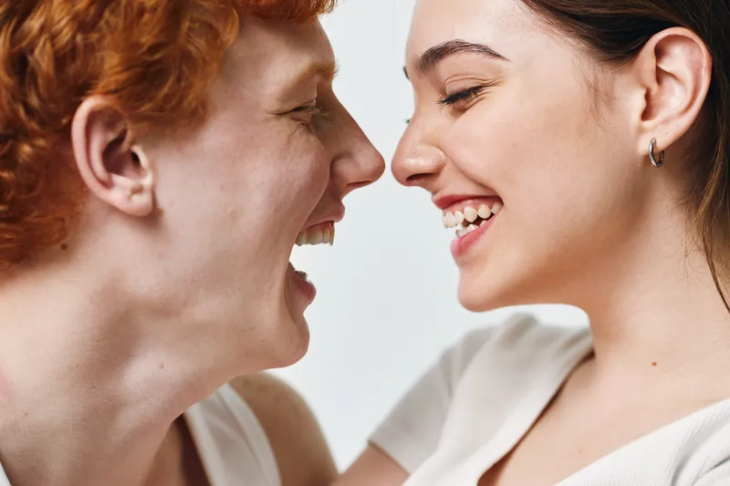 Couple laughing and looking at each other with joy and happiness closeup. Young man and woman enjoying moment of togetherness and love in casual style.