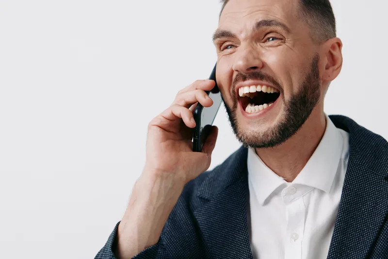 Professional man on a call, expressive and confident, showcasing business energy against an isolated colored backdrop; a bold moment of leadership and emotion.