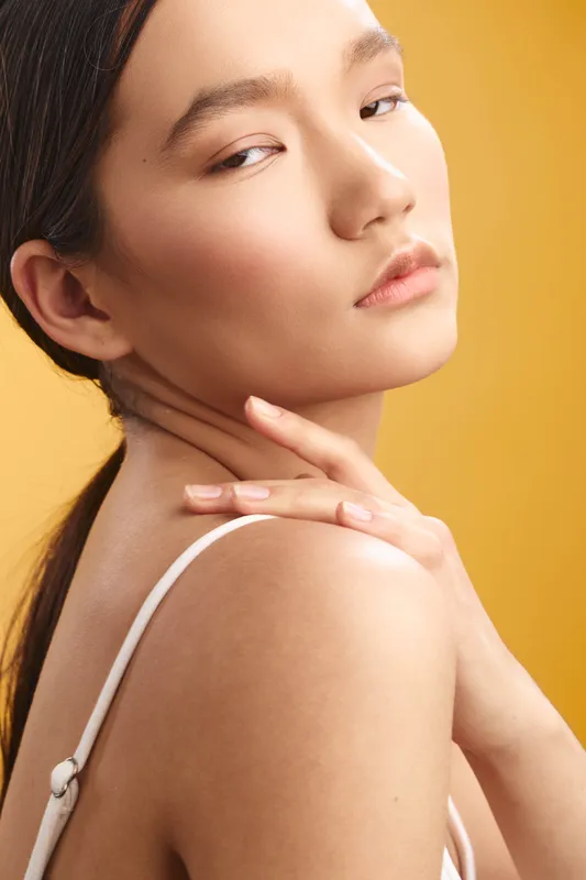 asian woman in a closeup portrait, with soft makeup and warm lighting, her calm expression and poised gaze convey grace, confidence, and timeless beauty.
