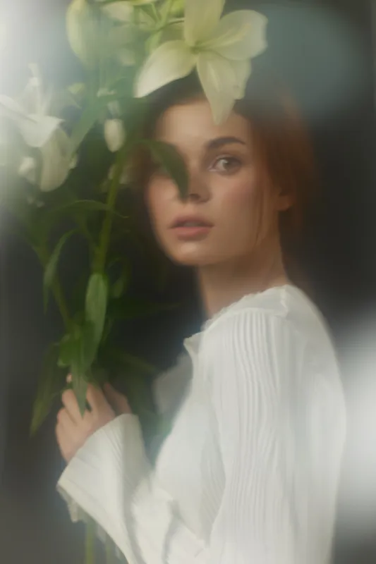 Ethereal Portrait of a Young Woman Holding White Lilies in a Soft, Dreamy Setting, Capturing Emotions of Serenity and Beauty