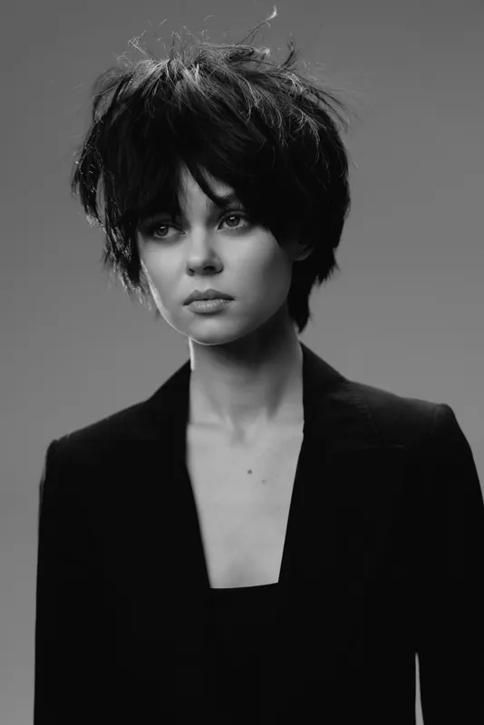 black and white portrait of a young woman with short dark hair and serious expression wearing a black blazer