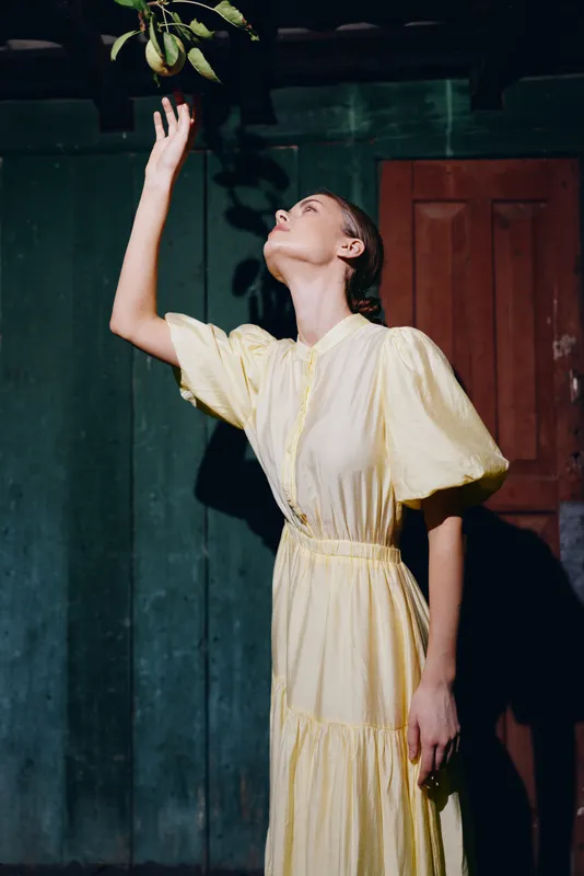 Woman in yellow dress reaching apple authenticity inclusivity