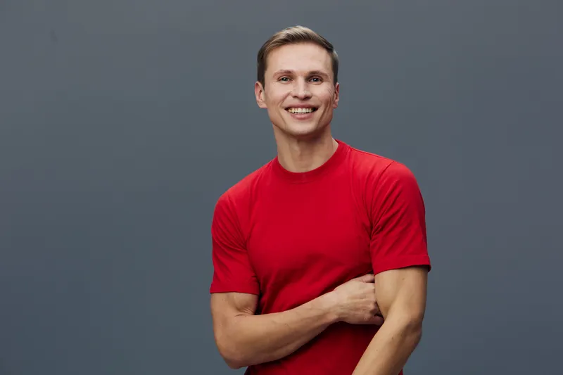 smiling man wearing red tshirt looking at camera isolated on gray background positive emotion casual style digital detox concept