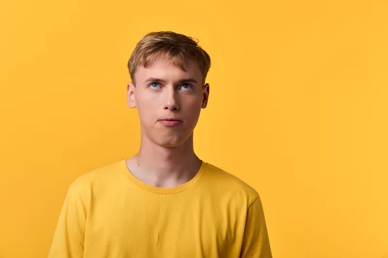 Man in yellow tshirt against a bright yellow background, casual studio mood, clear view of face, clean composition, bold color study suitable for fashion and advertising concepts