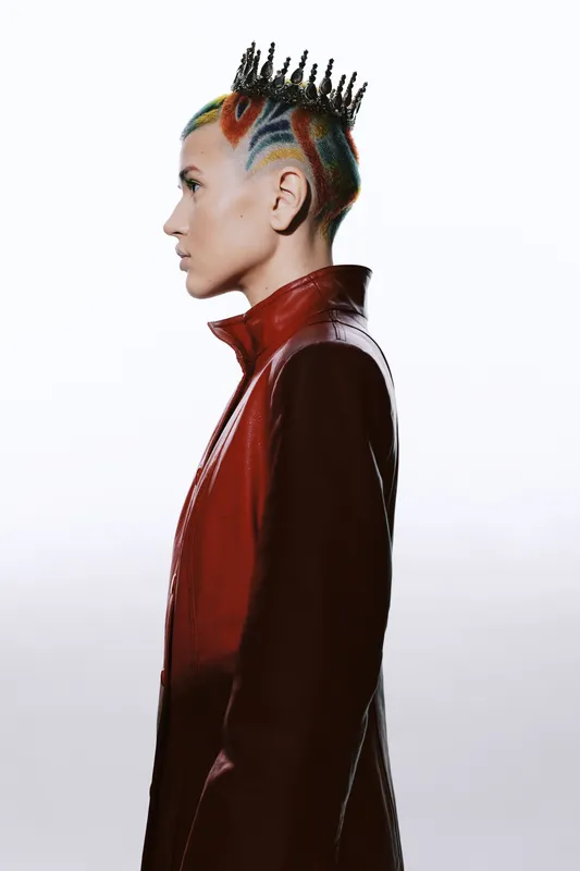 profile of a woman with colorful braided hair wearing a red leather jacket and a unique hair crown, isolated on white background, modern fashion portrait