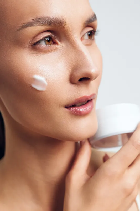 Woman applying face cream, closeup skincare beauty wellness concept, soft studio lighting on clean background, smooth skin hydration, gentle routine for care and comfort, spa relaxation