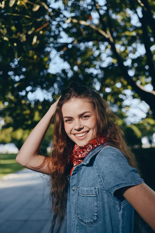 smiling woman in modern boho-western denim street style with bandana, natural light, outdoor urban background, film color tone, lifestyle mood