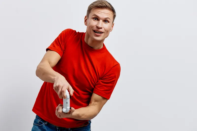 excited smiling man red t-shirt holding game controller play video game home digital entertainment concept