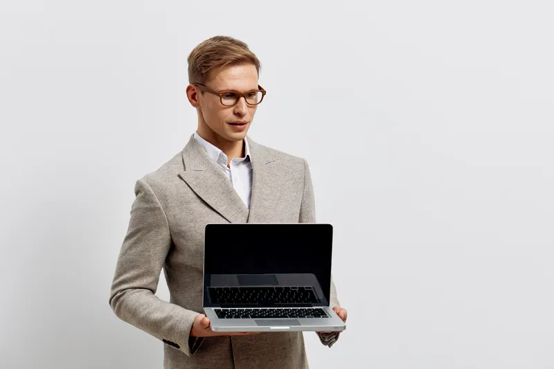 young caucasian man hold laptop look down wear glasses check digital nomad remote work technology concept white background