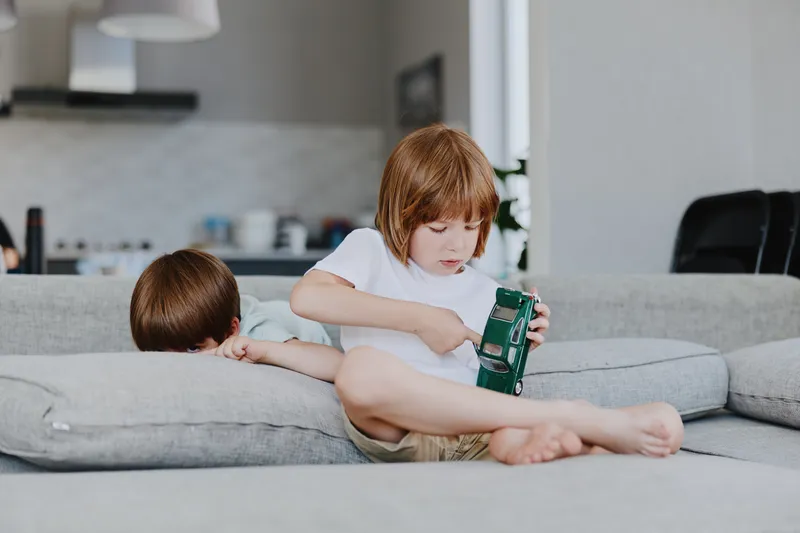 Focused boy and girl playing together indoors, enjoying a creative moment. Their playful expressions showcase the joy of childhood and sibling bonding.
