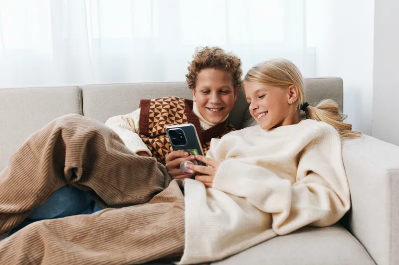 Authentic scene of a home game session with siblings, showcasing playful interaction, warmth, and focus as they enjoy a casual moment after school and create memory.
