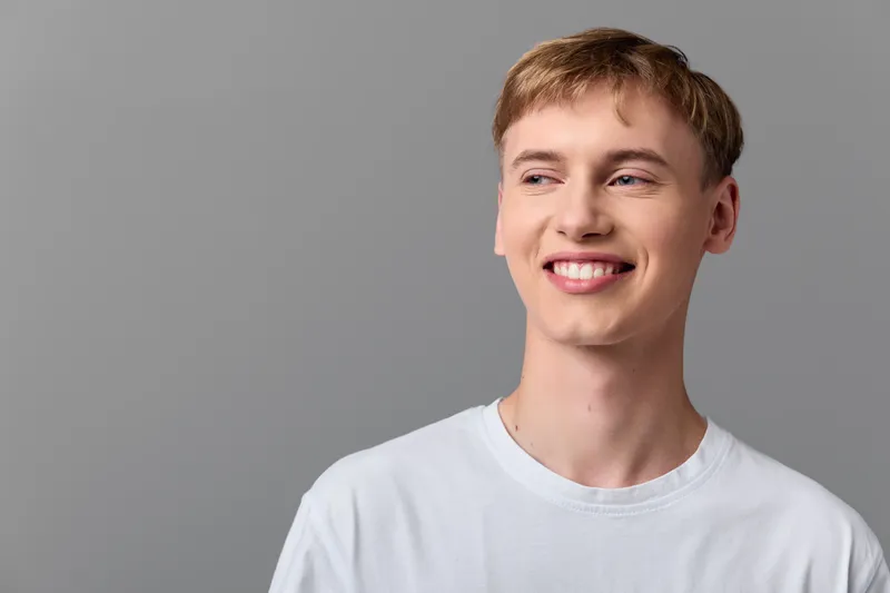 Smiling man in a casual t shirt against a neutral background, with studio light creating a warm, friendly vibe suitable for lifestyle, advertising and corporate visuals