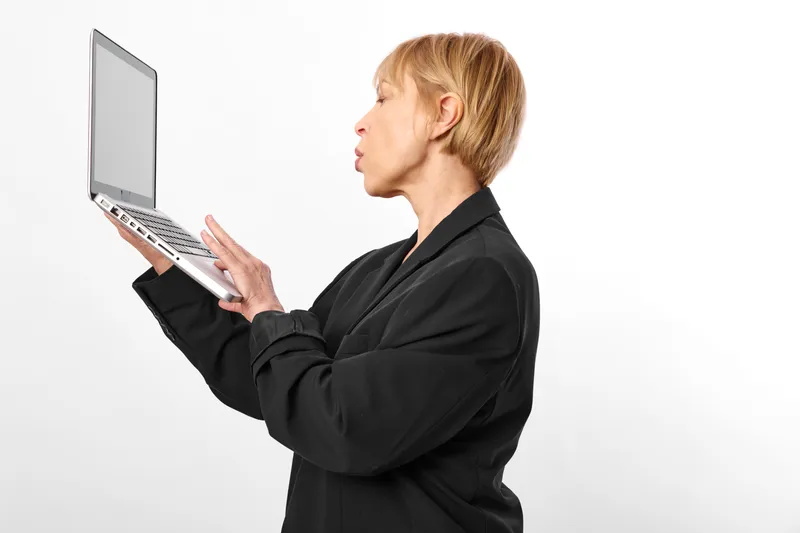 Woman, laptop, business, technology, communication, portrait, profile, blonde, computer, typing, black blazer, holding open laptop, speaking gesture, white studio backdrop