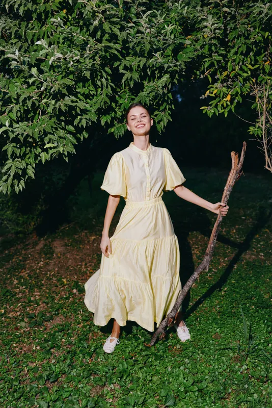 woman in yellow dress outdoors smiling with authenticity inclusivity vibe