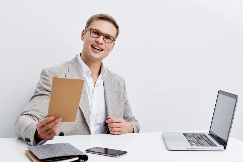smiling young man working laptop chatting with AI digital nomad wearing glasses grey blazer white shirt isolated white background remote work technology concept