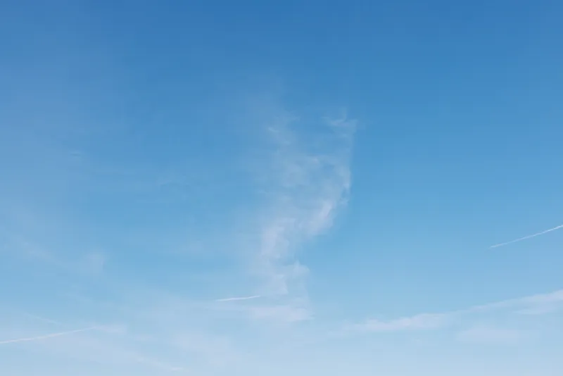 Blue sky with wispy clouds, vast open space perfect for backgrounds, calm weather and serene atmosphere for outdoor scenes and minimalist compositions