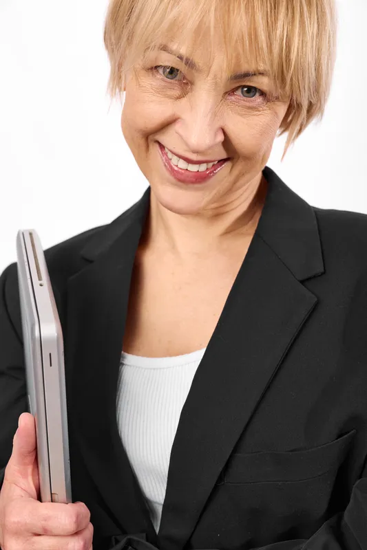 Senior woman portrait, blond hair, smile, holding smartphone, wearing business suit, studio lighting, white background, closeup, professional demeanor, calm