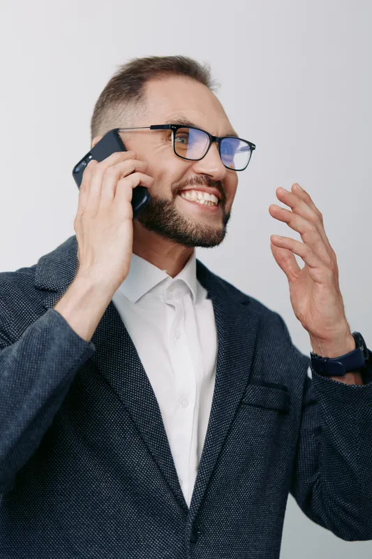 A professional businessman on an isolated colored background speaks on a call, exuding confident energy, focus, and determination in a dynamic, modern mood.