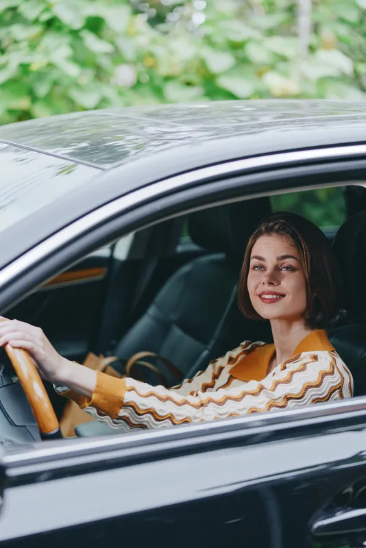 Car, driver, woman, smile a cheerful woman sits behind the wheel with a warm smile, poised and confident, ready for a journey and enjoying the driving moment