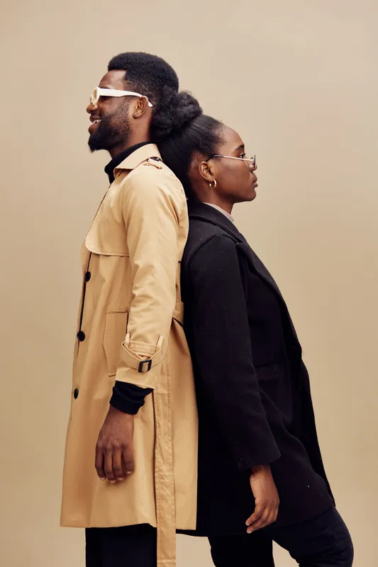 Stylish urban couple in fashionable outfits against a neutral background, showcasing elegance and confidence with coordinated looks