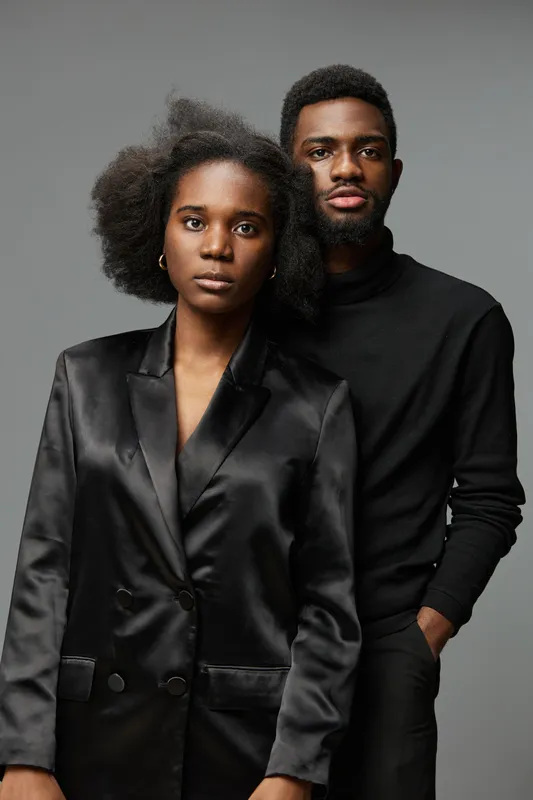 Portrait of a fashionable Afro American couple showcasing confidence and style on a neutral backdrop, ideal for concepts related to love, beauty, and modern relationships
