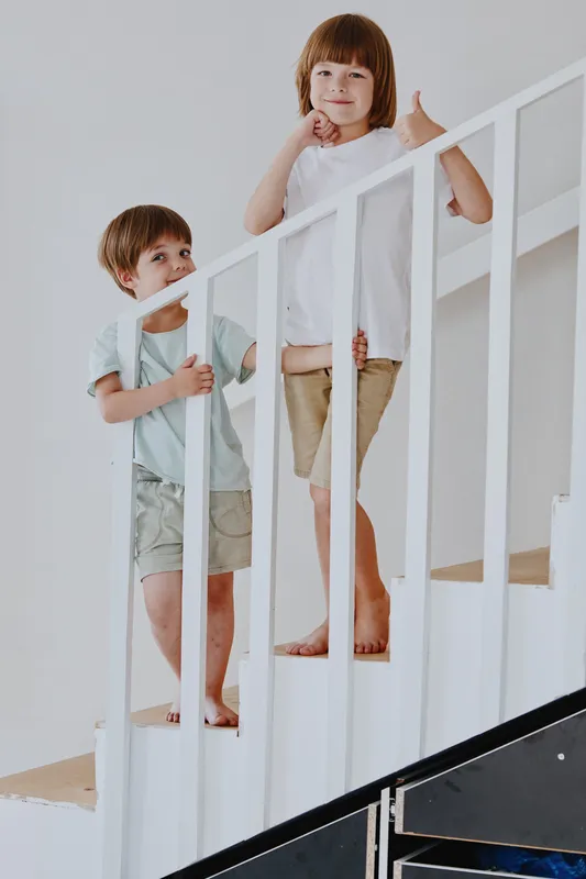 Two children climbing stairs, showcasing joy and playfulness with bright colors and a cheerful environment that highlights their adventurous spirits.