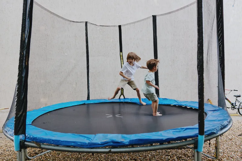 Joyful children bouncing on a trampoline, enjoying playful moments with fun and laughter. A great outdoor activity for summer adventures.