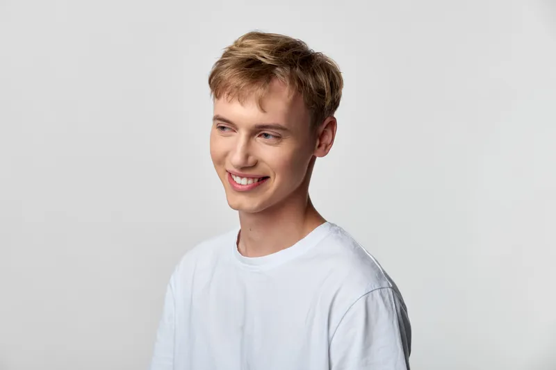 Man with a casual look, bright smile and light tshirt in a studio setting, conveying friendly warmth, approachable mood and modern, clean aesthetics for stock imagery and lifestyle campaigns