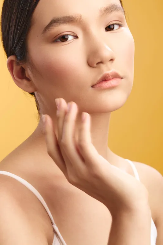 asian woman in a beauty portrait, close up shot with soft lighting, smooth complexion, and delicate expression, conveying calm confidence and subtle elegance in studio ambience
