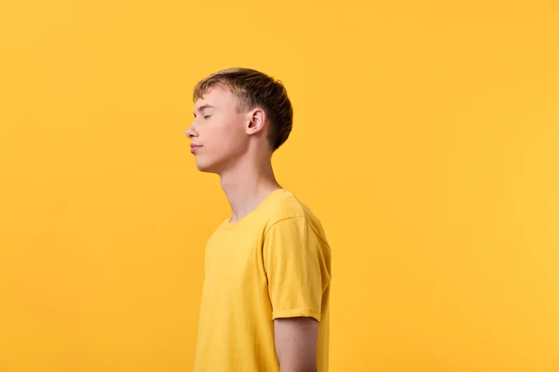 Side profile of a young man in a yellow tee against a bright yellow background, conveying calm, focus and minimalism for lifestyle, fashion, or creative concept projects