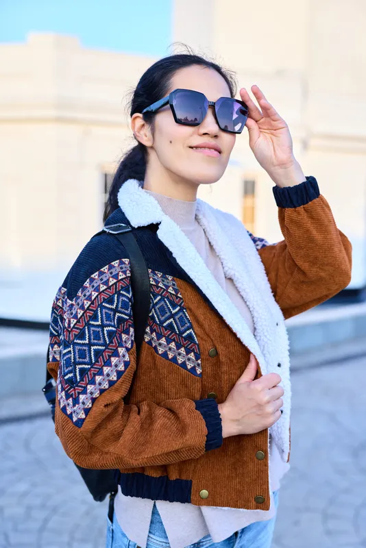 Fashion, style, sunglasses, jacket, streetwear, urban, outdoors, backpack, confident expression and chic outerwear under daylight in a stylish city street scene
