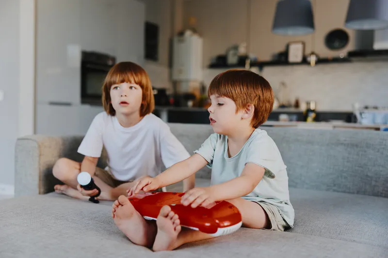 Engaged children playing with a musical toy in a cozy living room, showcasing creativity and joy in a modern home environment.