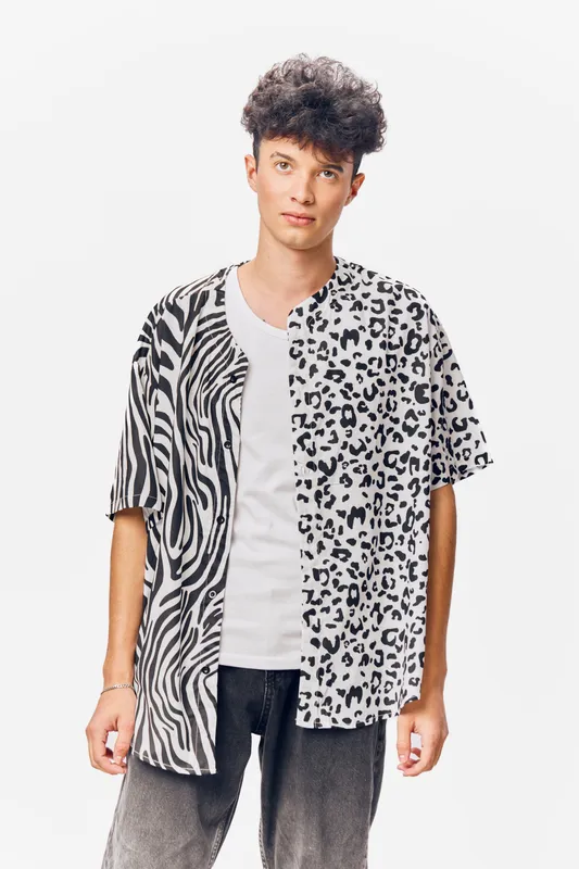 young man wearing a half zebra half leopard print shirt with curly hair, casual style, standing on a white background, modern fashion look
