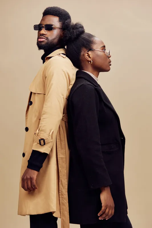 Stylish African couple in modern attire, showcasing contemporary fashion with a neutral background Emphasizing elegance and confidence in their poses