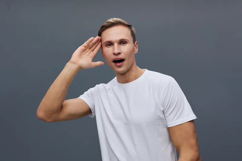 Young man talk chatbot use smartphone gesture excited facial expression casual white tshirt gray background technology cyber security concept