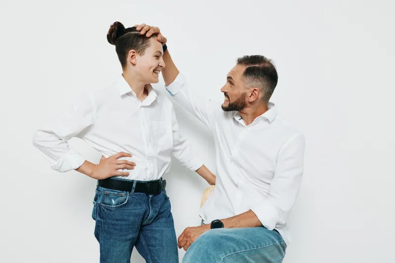 Professional man with a warm smile engages with a colleague on a solid white background, showcasing leadership, teamwork, and positive emotion in a modern business scene.