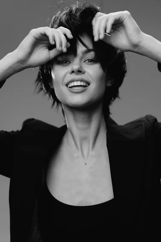 smiling woman with short hair in black and white portrait expressing happiness and confidence