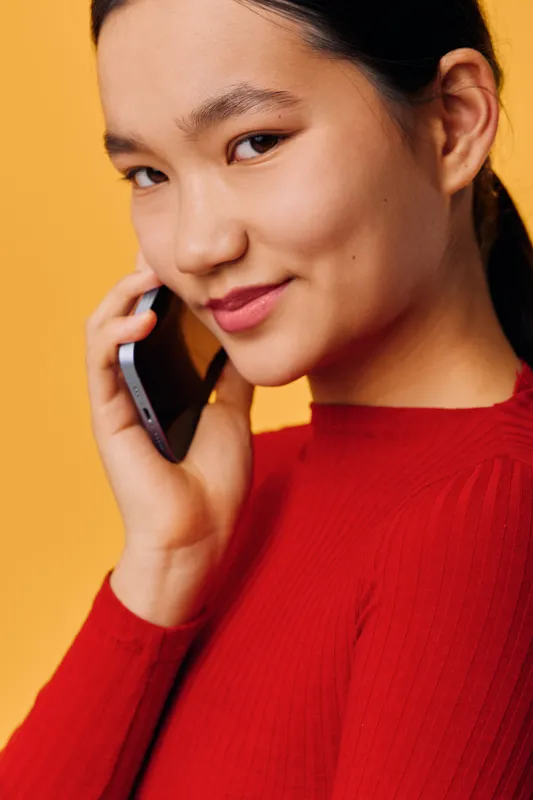 Woman, phone, call, communication, smile, red, portrait, Asian, young, casual speaking on smartphone with happy expression and orange background for connection and technology.
