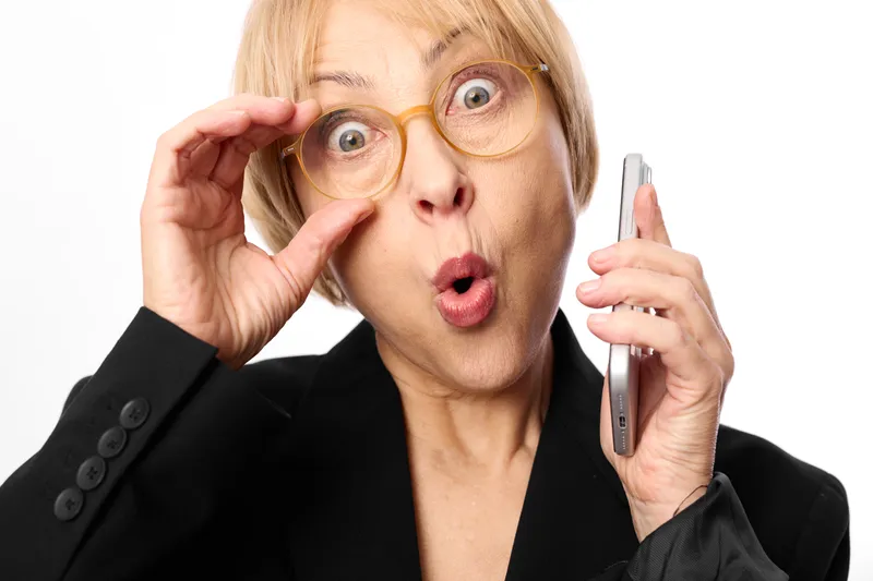 Woman in business portrait with surprise emotion, holding eyeglasses and a pen with glasses, shocked expression, looking at camera, isolated on white background for office concept