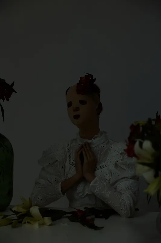 A surreal artistic portrait of a doll like figure in white lace, surrounded by flowers, conveying emotions of contemplation and nostalgia, ideal for themes of identity and femininity